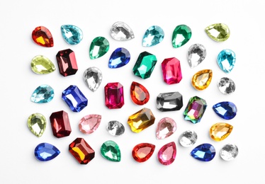 Different beautiful gemstones on white background, top view