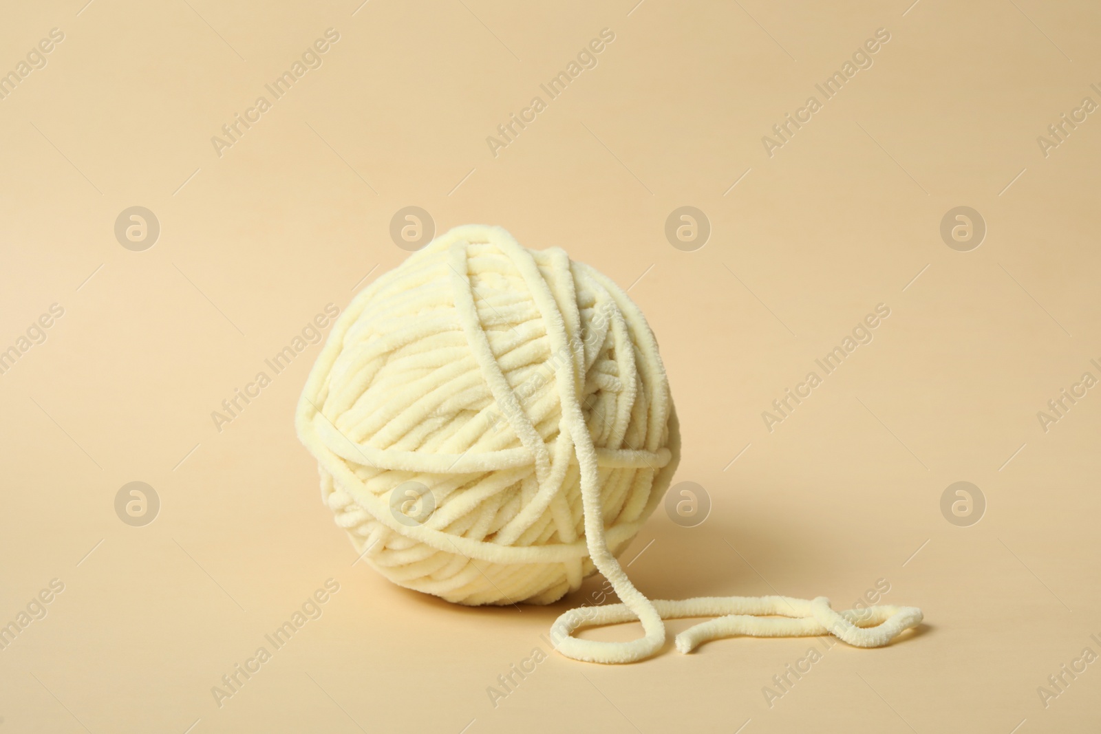 Photo of Soft colorful woolen yarn on beige background