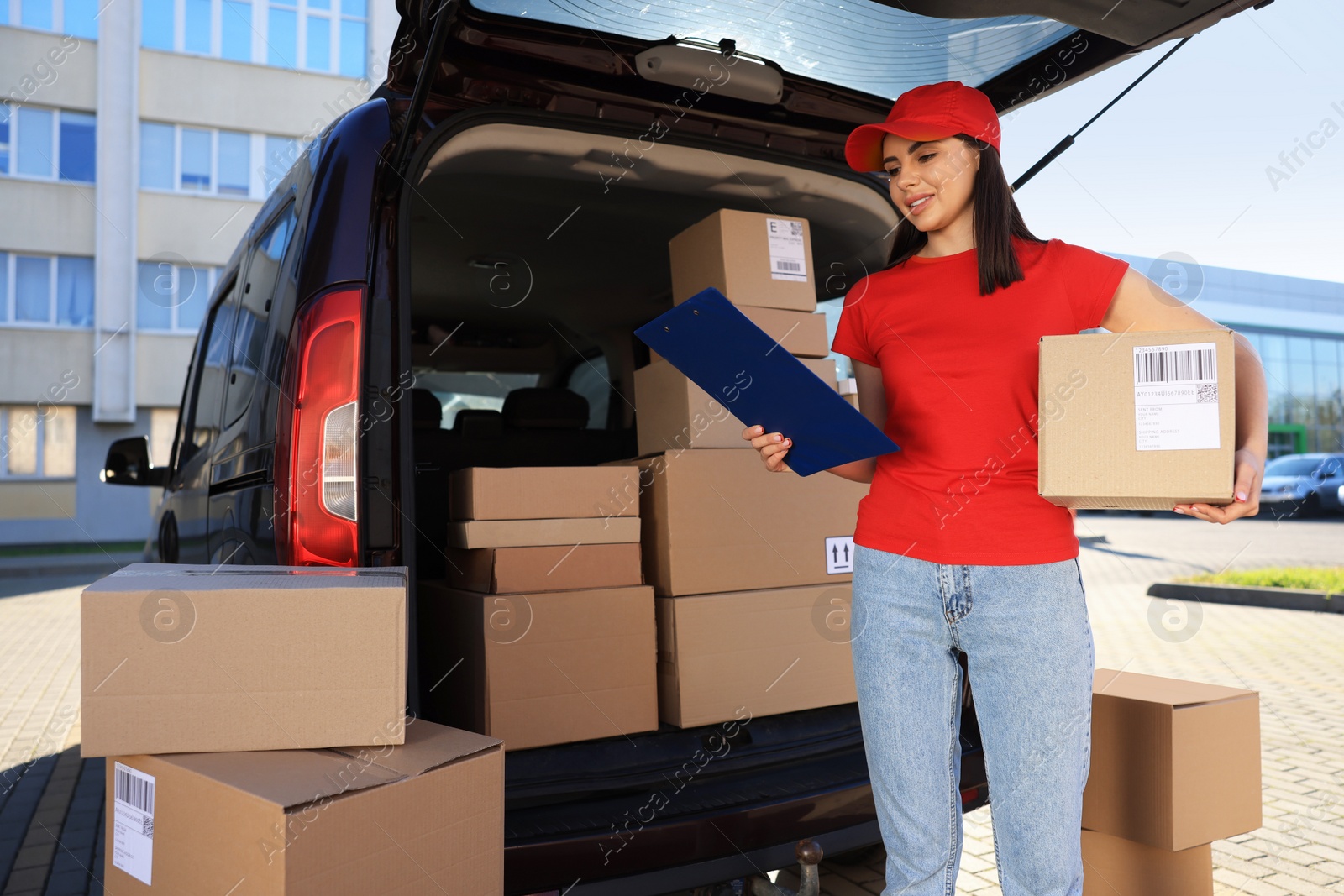 Photo of Courier with parcel and clipboard near delivery van outdoors