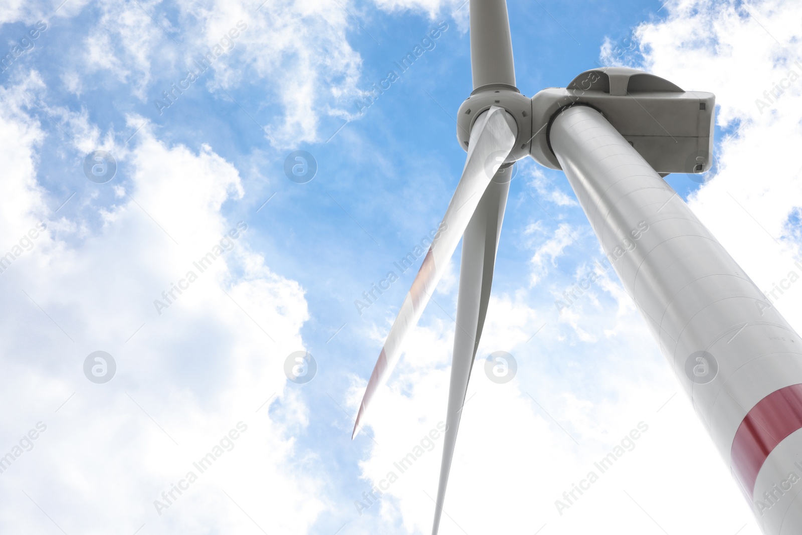 Photo of Modern wind turbine against cloudy sky, low angle view. Alternative energy source