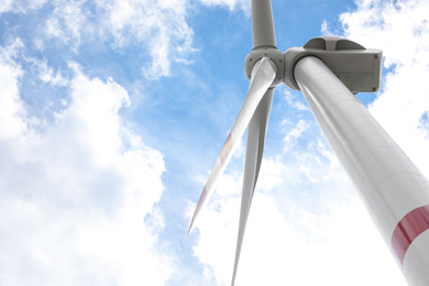 Modern wind turbine against cloudy sky, low angle view. Alternative energy source