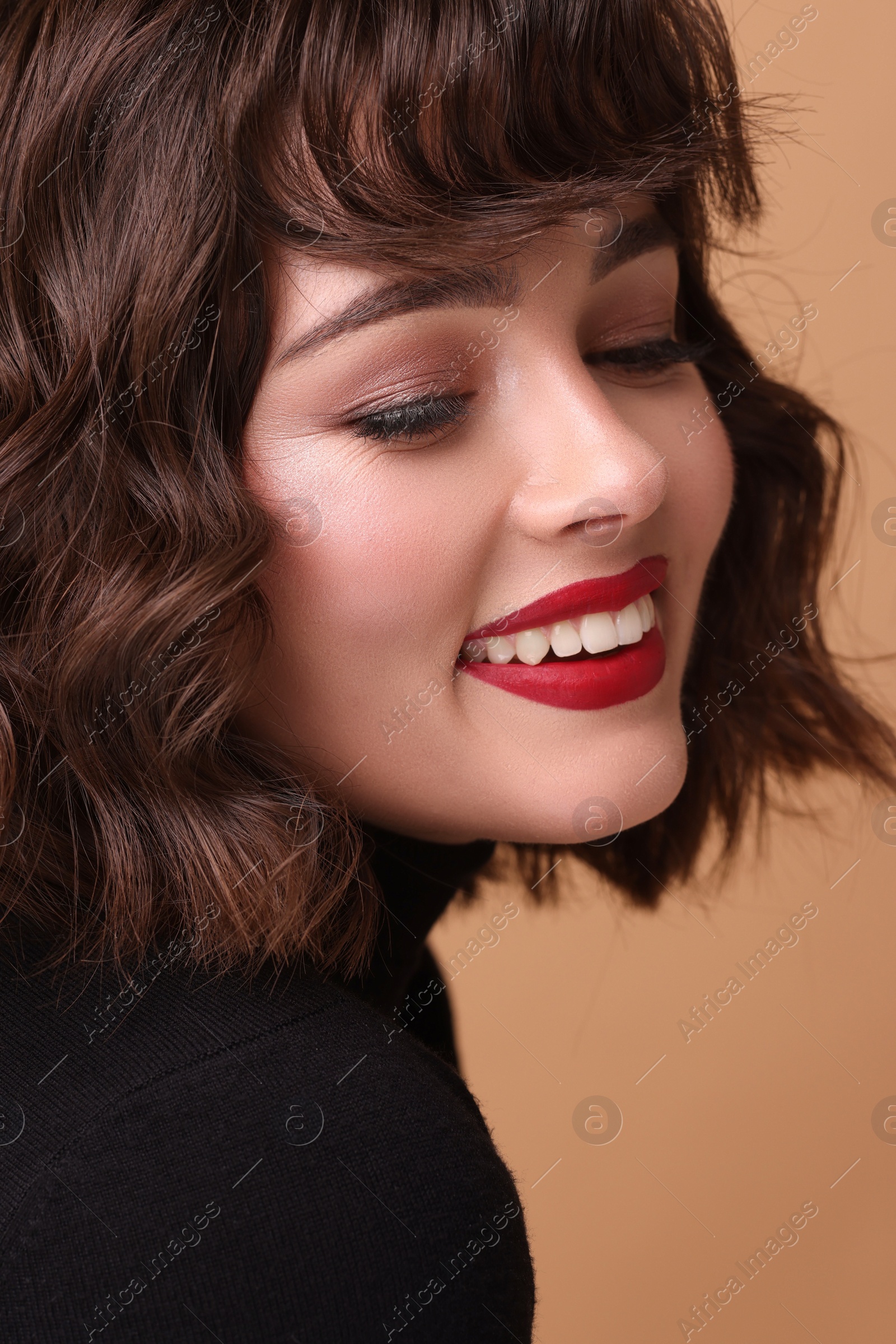 Photo of Beautiful young woman with wavy hairstyle on beige background