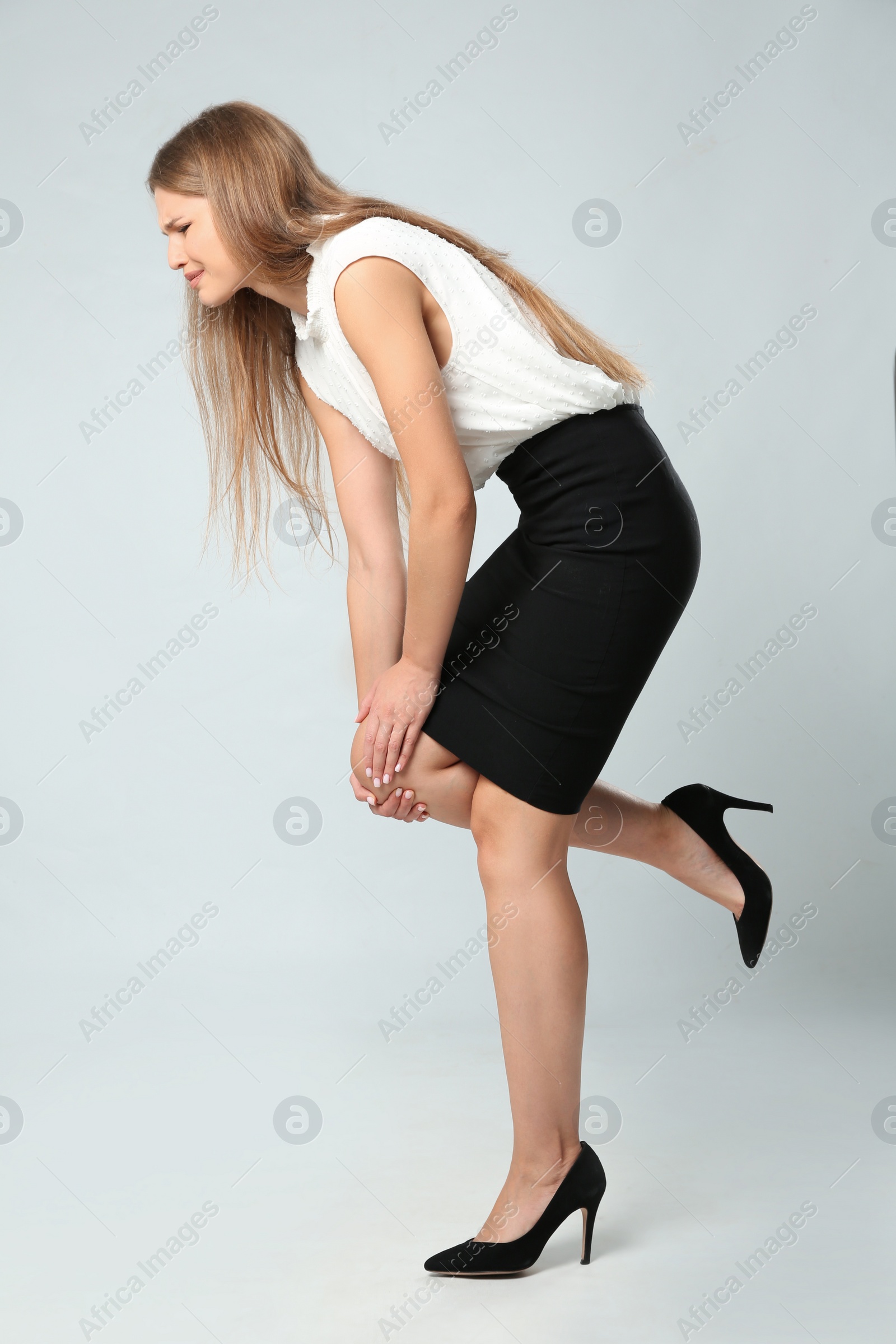 Photo of Full length portrait of businesswoman having knee problems on grey background