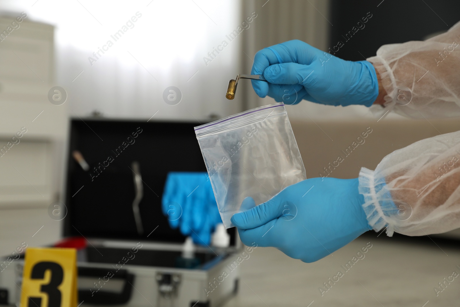 Photo of Investigator in protective gloves working with evidence indoors, closeup. Crime scene