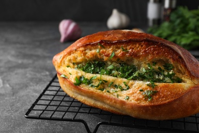 Photo of Delicious homemade garlic bread with herbs on grey table, closeup