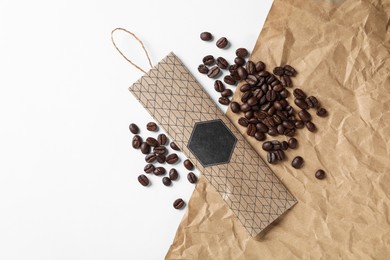 Scented sachet and coffee beans on white background, flat lay