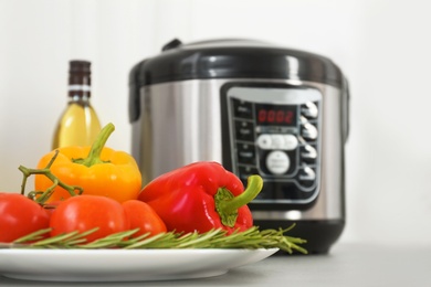 Photo of Modern multi cooker and products on kitchen table