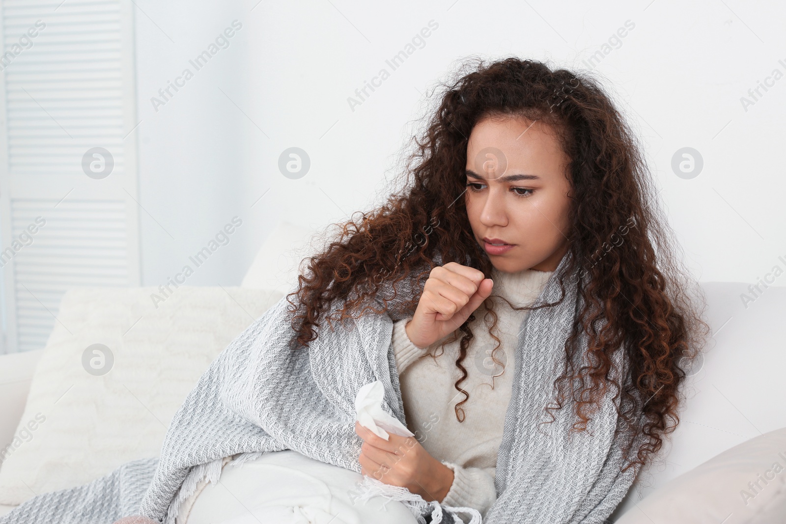 Photo of Sick African American woman coughing at home