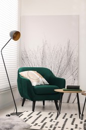 Photo of Comfortable armchair, lamp and table in stylish room