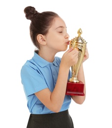 Photo of Happy girl in school uniform kissing golden winning cup isolated on white