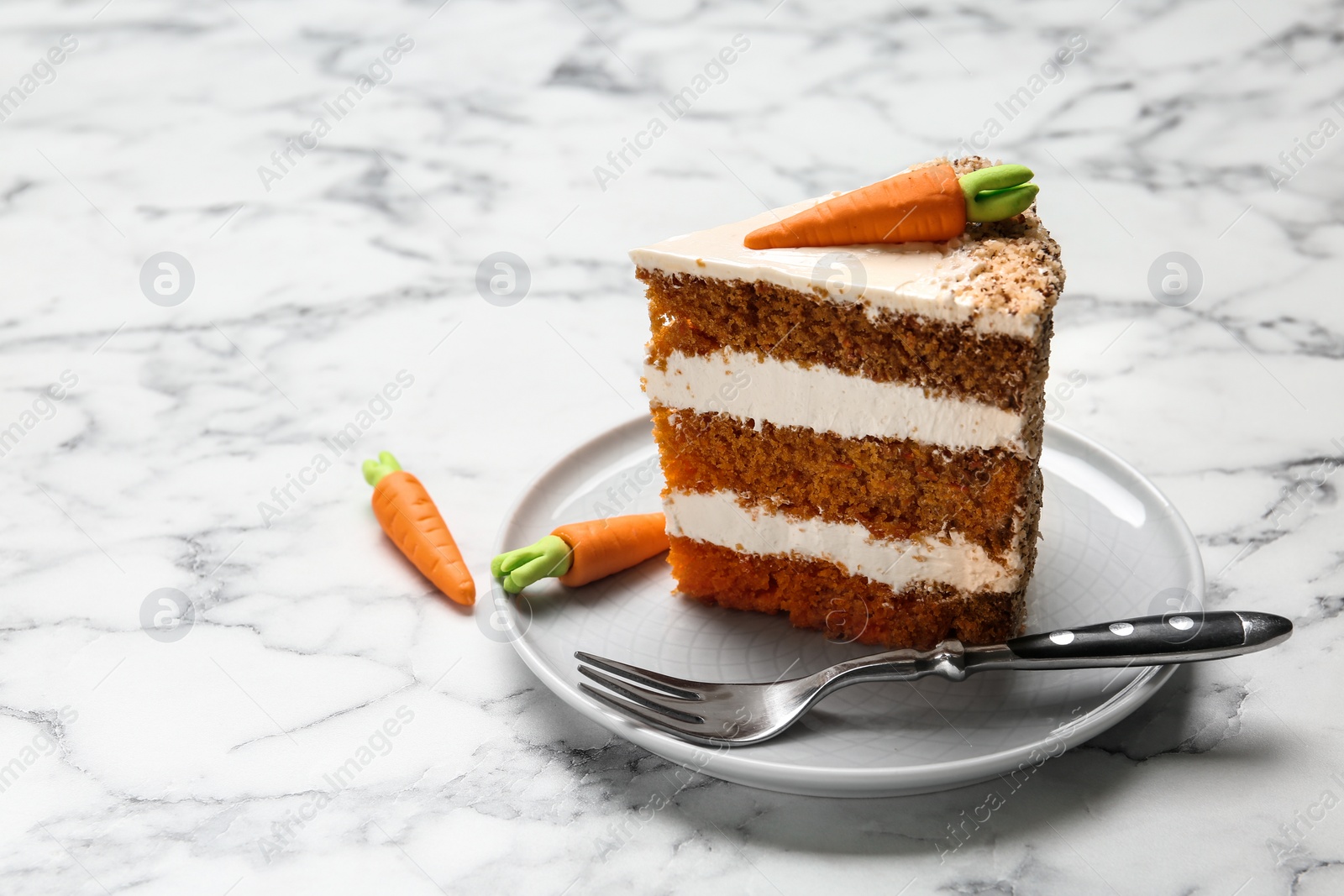 Photo of Piece of sweet carrot cake with delicious cream on white marble table. Space for text