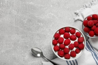 Photo of Bowl with delicious yogurt and raspberries on grey table, flat lay. Space for text