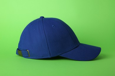 Stylish blue baseball cap on light green background