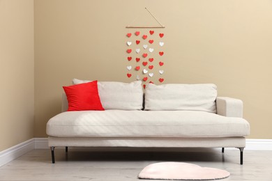 Photo of Cozy living room decorated for Valentine's Day with paper hearts. Interior design