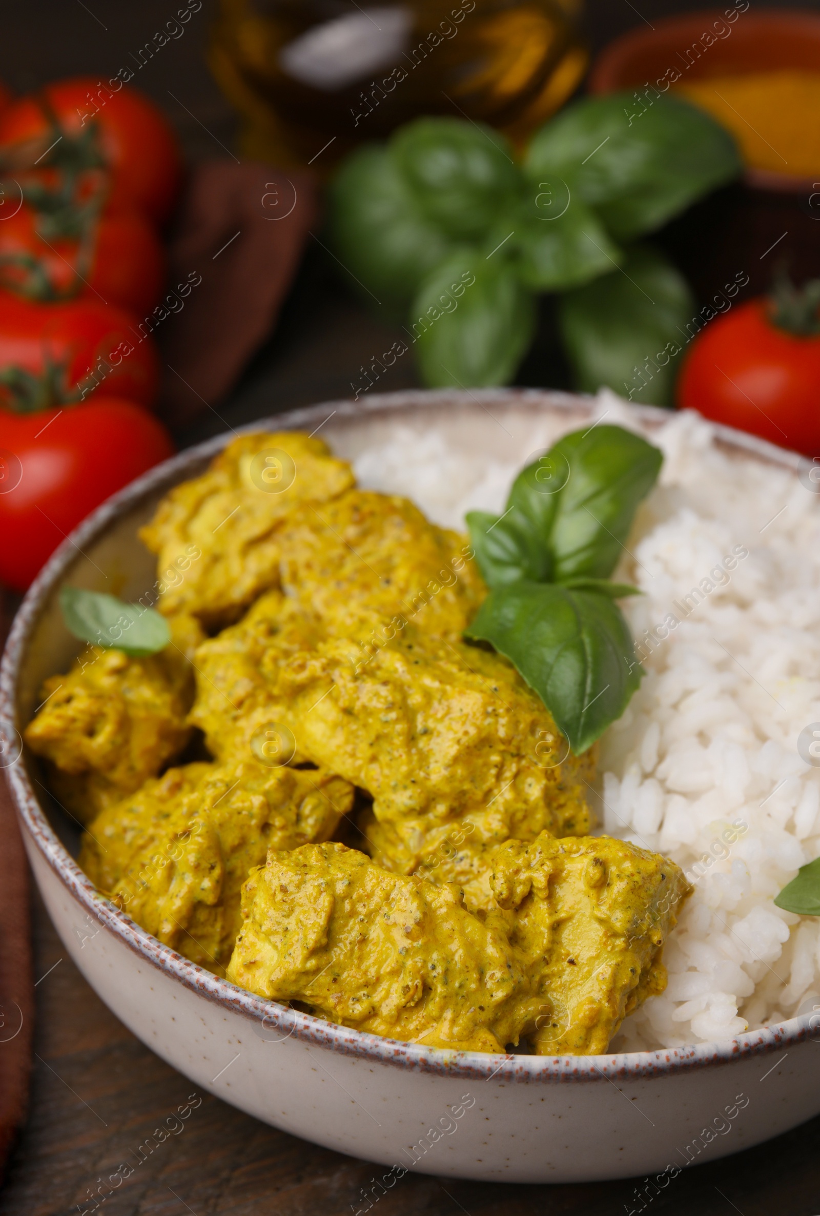 Photo of Delicious rice and chicken with curry sauce on wooden table, closeup