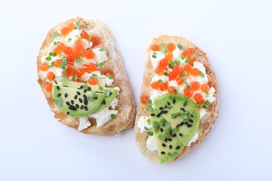 Delicious sandwiches with caviar, cheese, avocado and microgreens on white background, top view