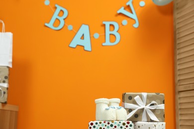 Photo of Baby shower party. Festive decor, booties and gift boxes indoors