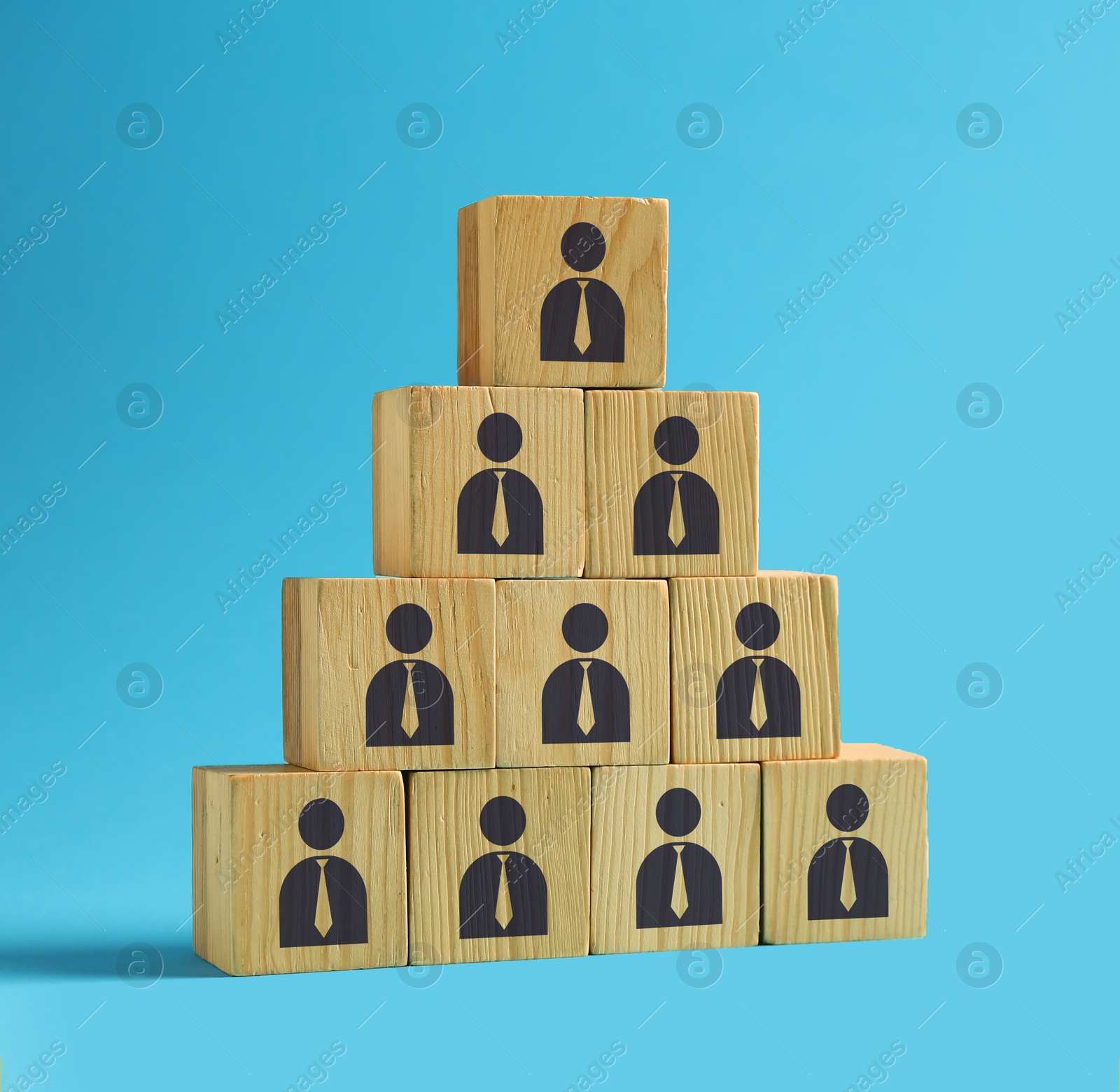 Image of Team and management concept. Pyramid of wooden cubes with human icons on light blue background