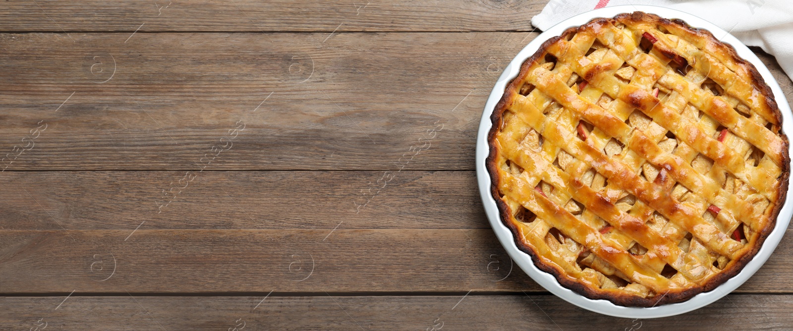 Image of Traditional apple pie and space for text on wooden table, top view. Banner design