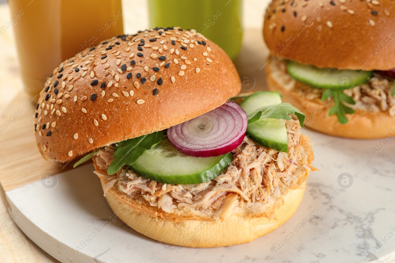 Photo of Delicious sandwiches with tuna and vegetables on serving board, closeup