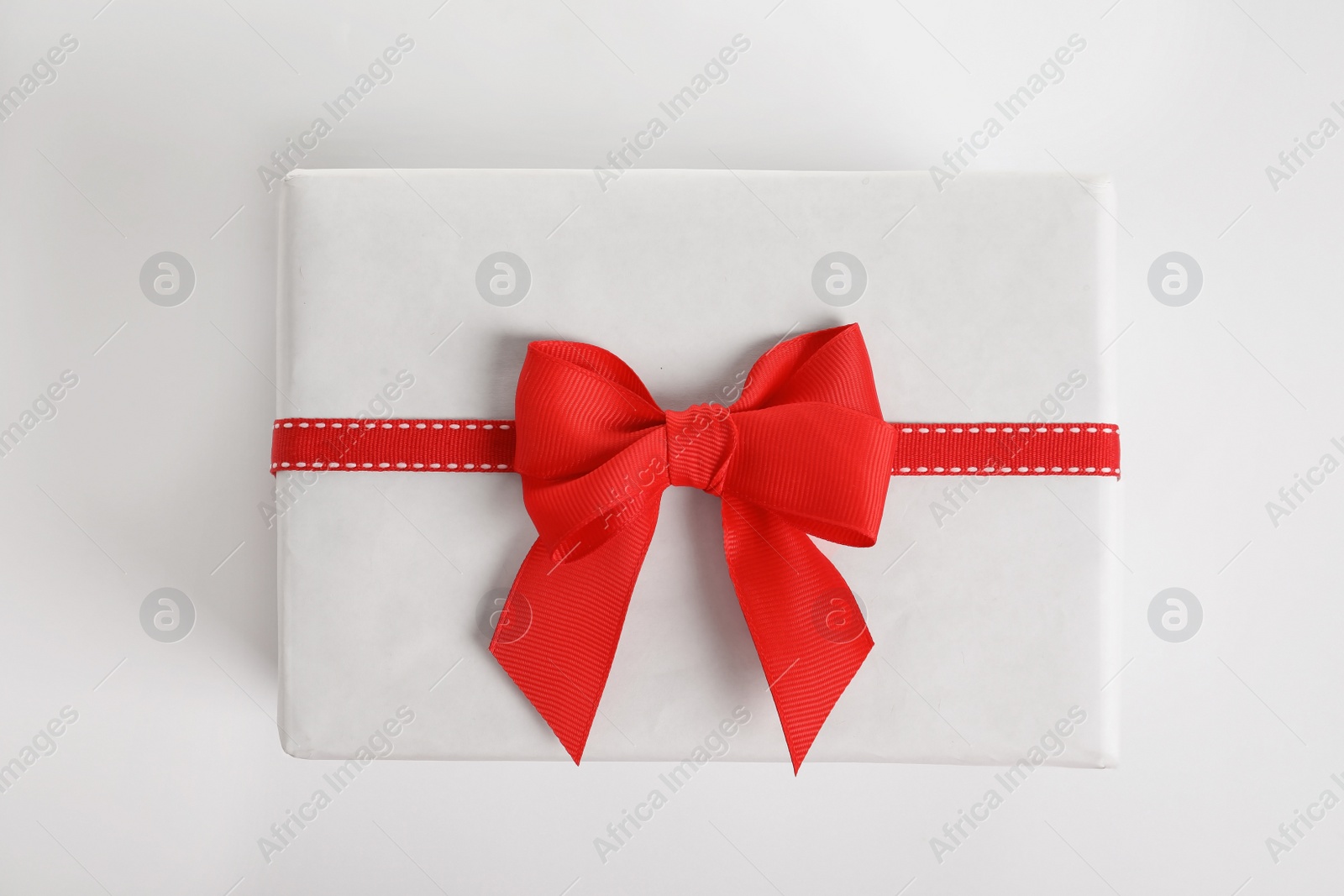 Photo of Beautifully wrapped gift box on white background, top view