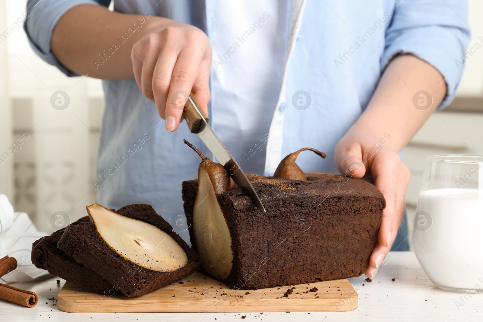 Photo of Woman cutting tasty pear bread at table, closeup. Homemade cake