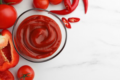 Photo of Bowl of tasty ketchup, tomatoes and peppers on white marble table, flat lay. Space for text