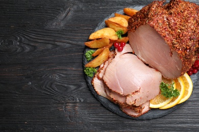 Photo of Slate plate with delicious ham and potatoes on grey wooden table, top view. Space for text