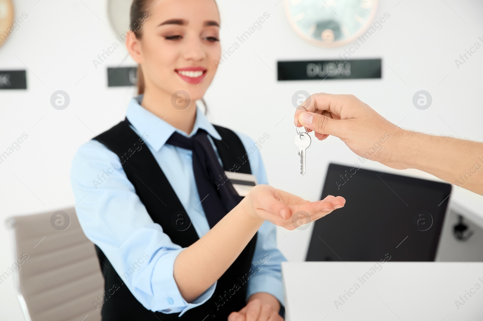 Photo of Young man giving key to receptionist in hotel