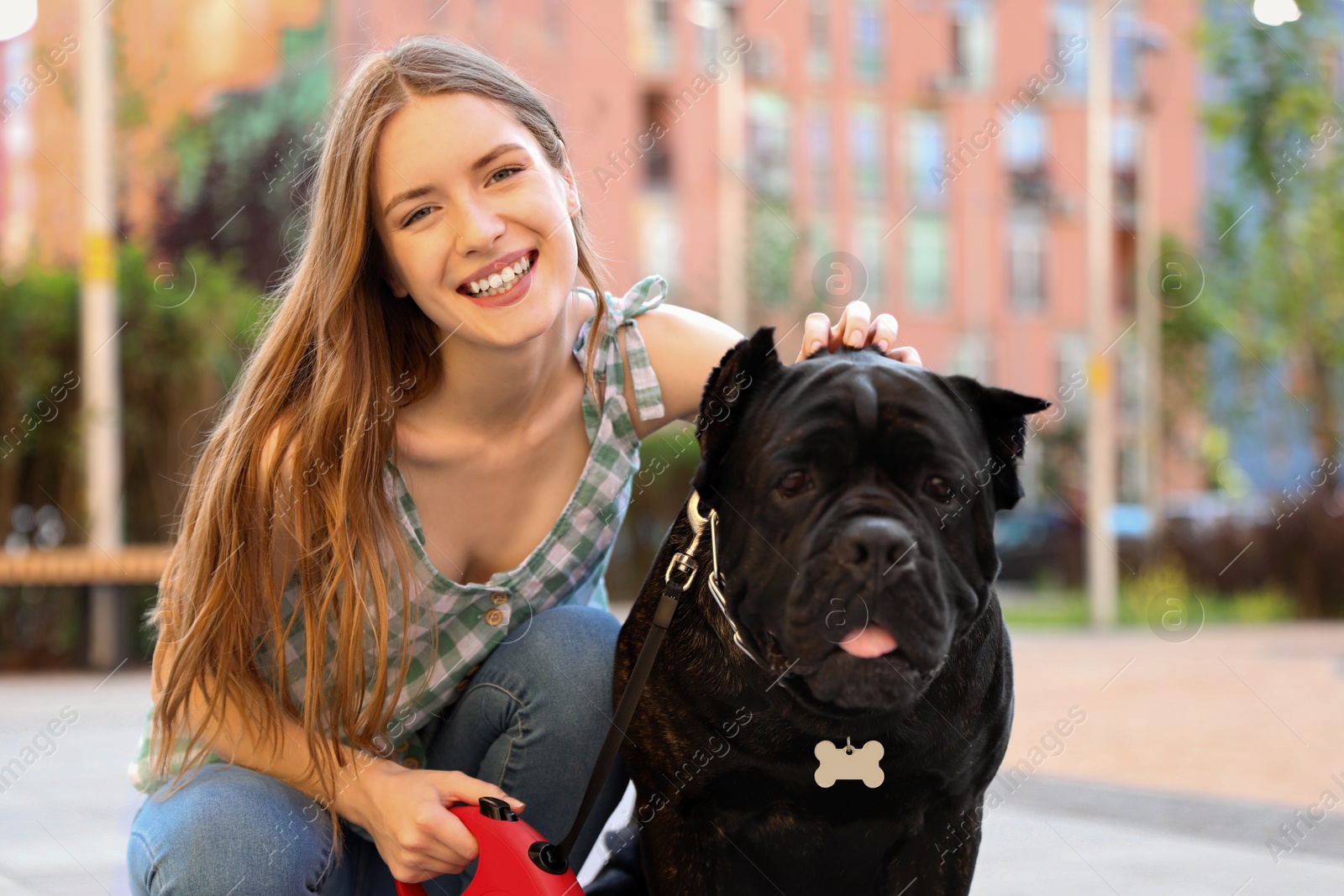 Photo of Young woman with American Staffordshire Terrier dog outdoors