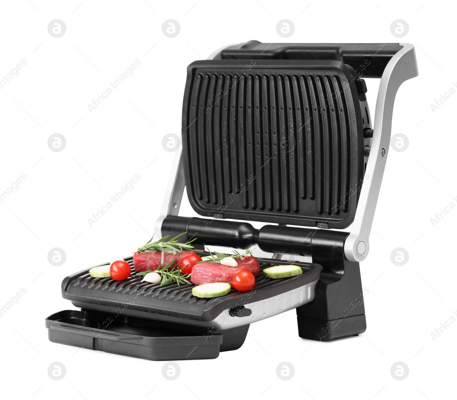 Photo of Electric grill with raw meat, rosemary and vegetables isolated on white