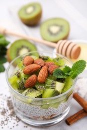 Delicious dessert with kiwi and almonds on white table, closeup