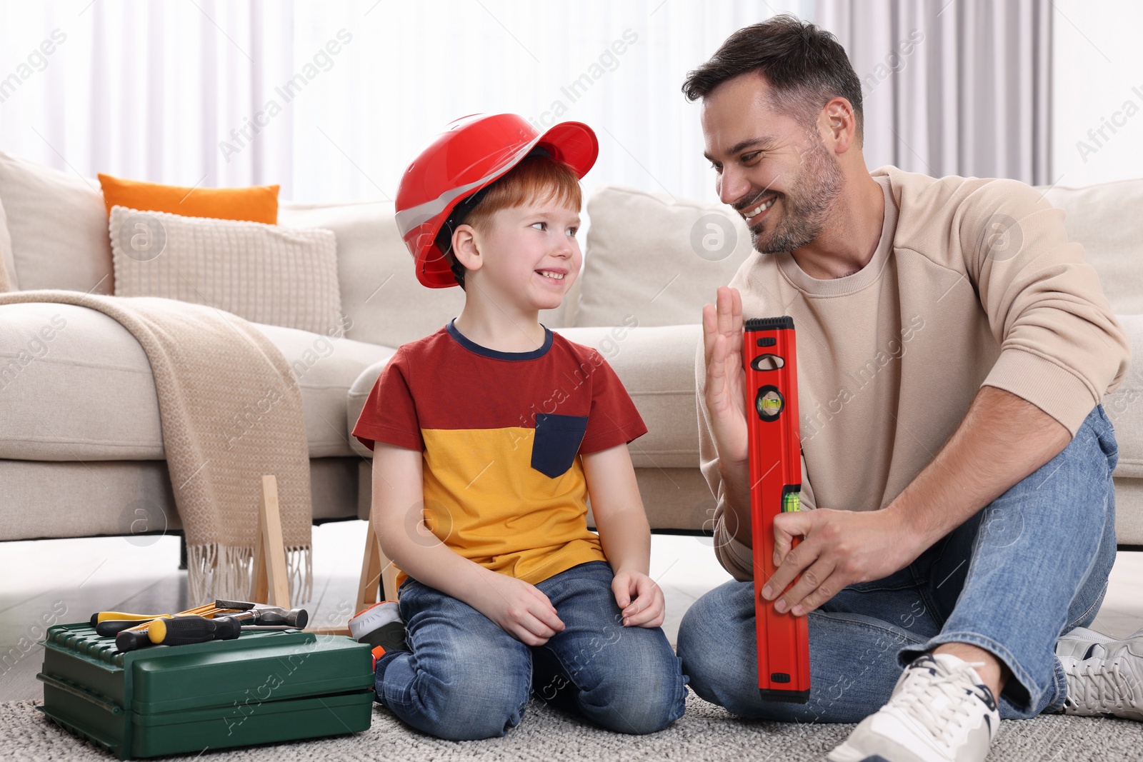 Photo of Father and son with bubble level at home. Repair work