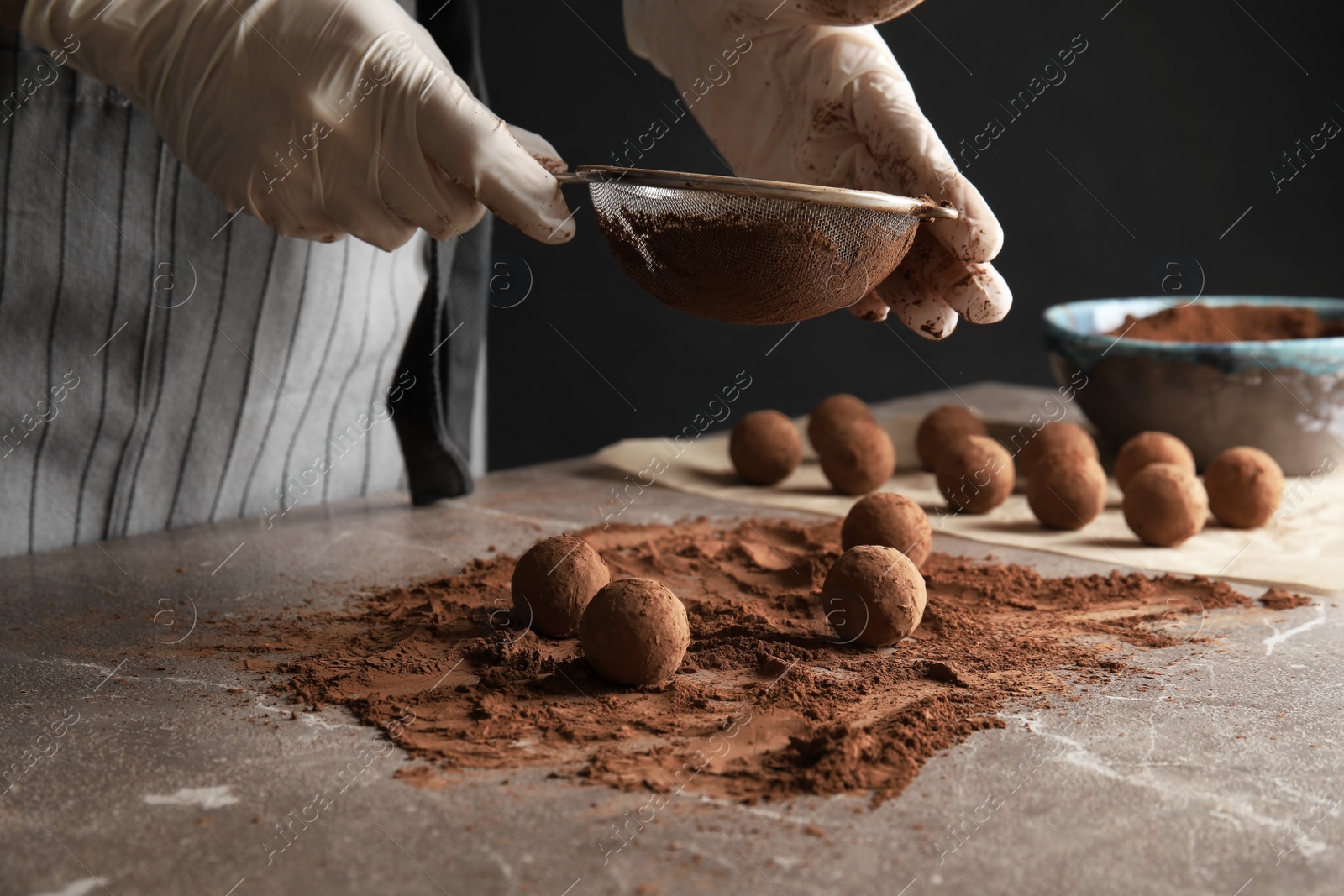 Photo of Woman preparing tasty chocolate truffles at table, closeup