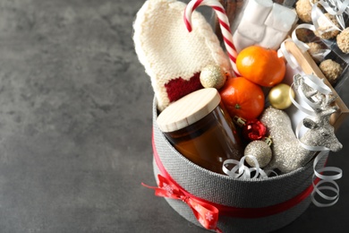 Basket with gift set and Christmas decor on grey table. Space for text