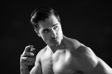 Photo of Handsome young man using perfume, black and white effect
