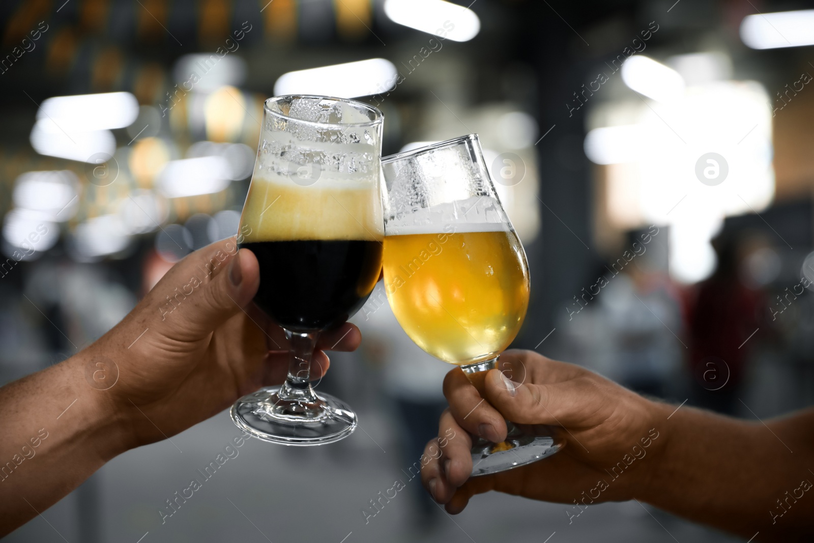 Photo of Men with glasses of light and dark beer in bar, closeup