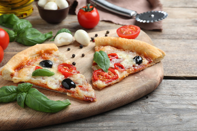 Photo of Pieces of delicious pizza Diablo on wooden table, closeup