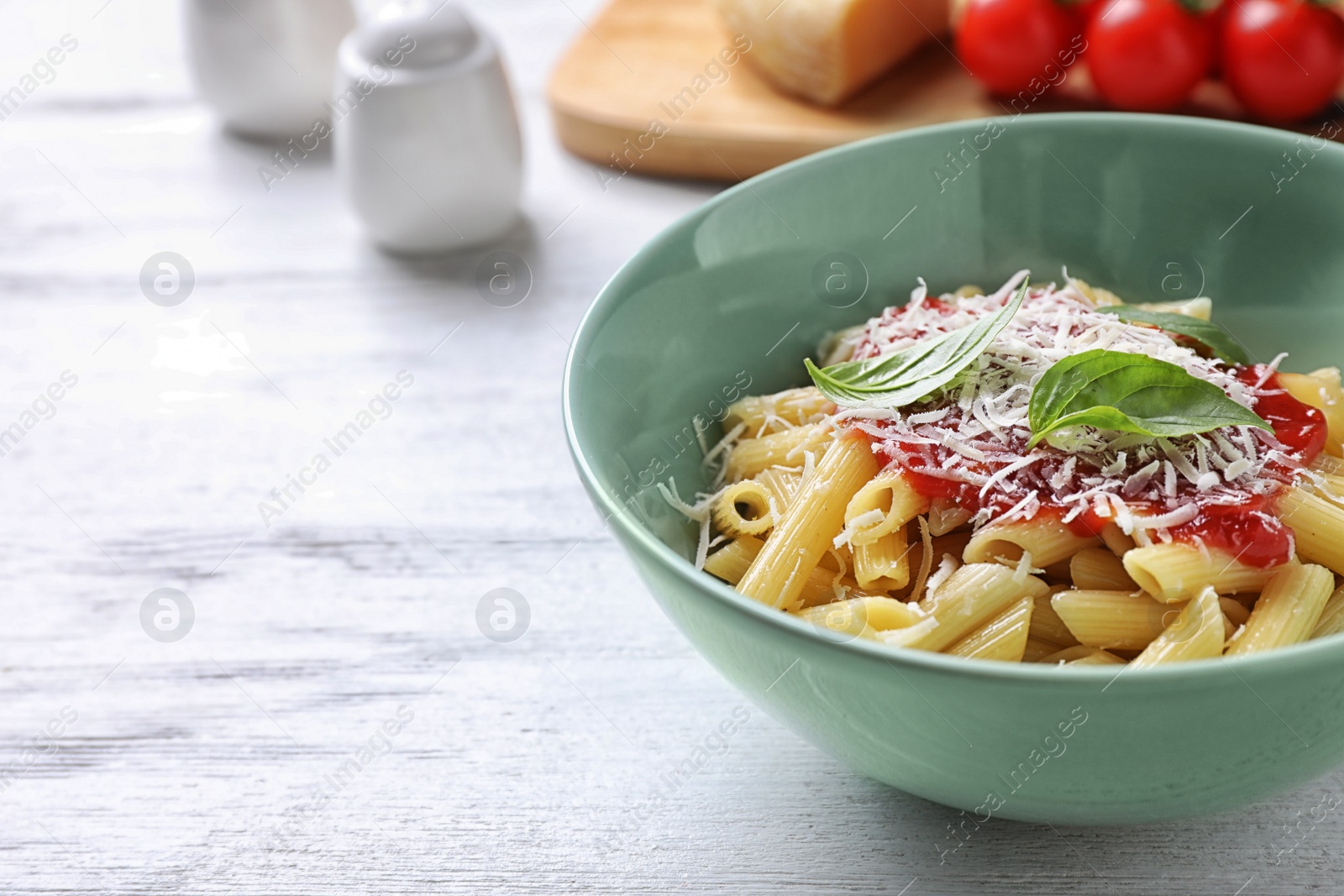 Photo of Delicious pasta with tomato sauce served on white wooden table, closeup