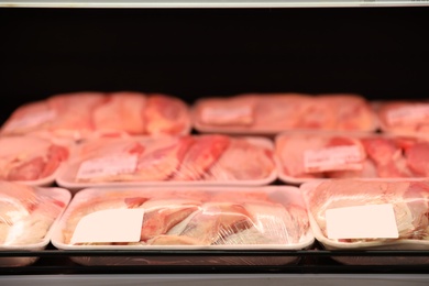 Shelf with packed chicken meat in supermarket