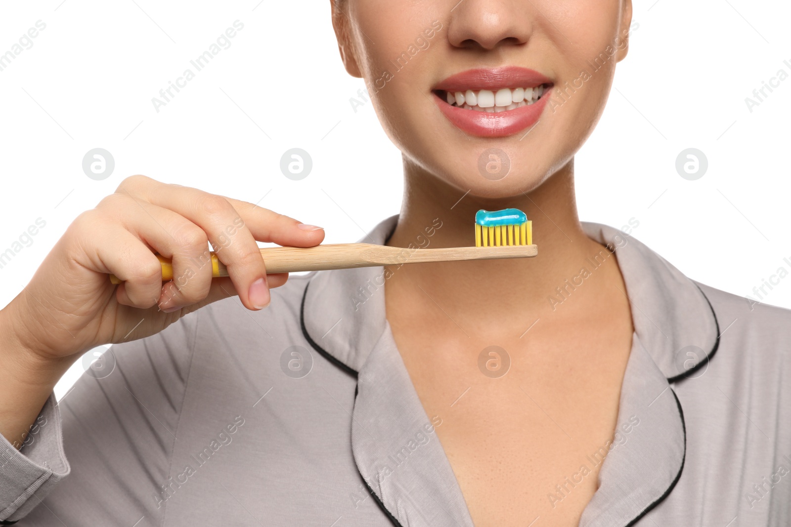 Photo of Woman holding toothbrush with paste on white background, closeup