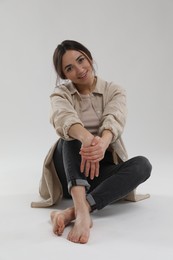 Portrait of beautiful woman on light grey background