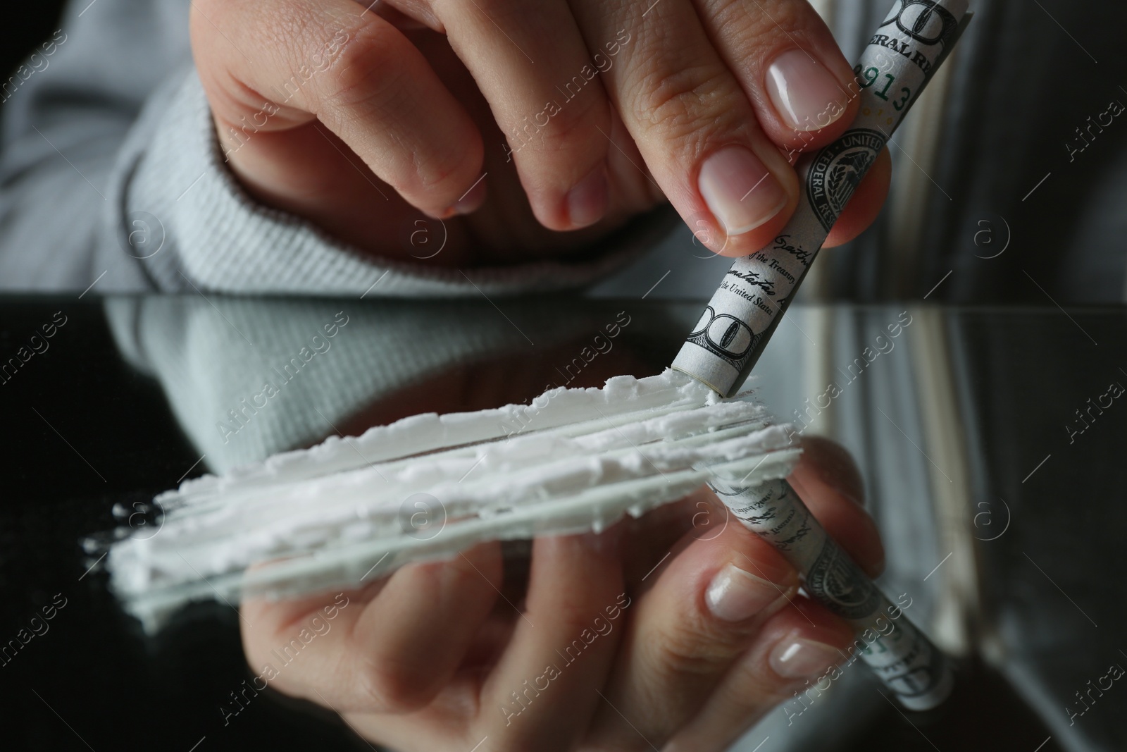 Photo of Drug addict taking cocaine at table, closeup view