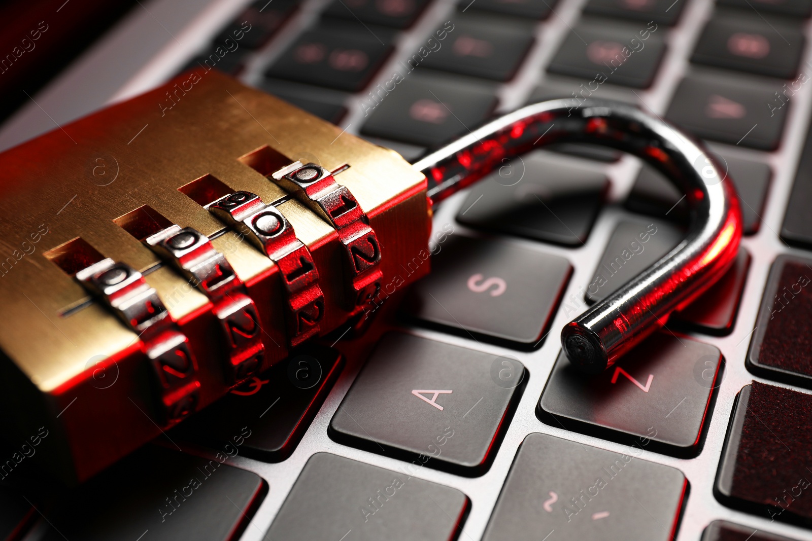 Photo of Cyber security. Metal combination padlock on laptop, closeup