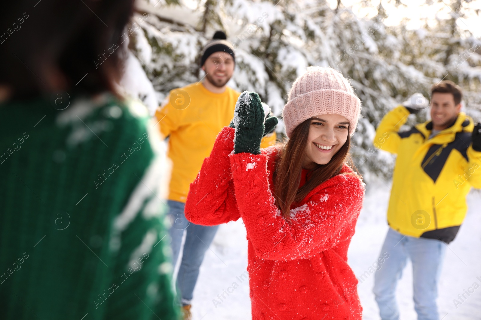 Photo of Happy friends playing snowballs outdoors. Winter vacation