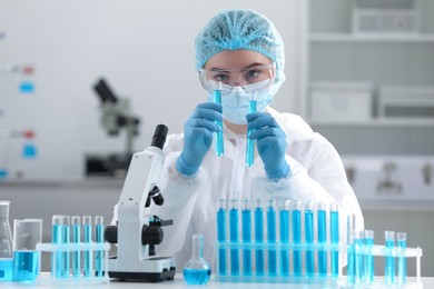 Photo of Scientist working with samples in test tubes in laboratory