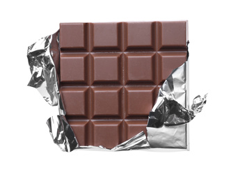 Photo of Delicious milk chocolate bar wrapped in foil isolated on white