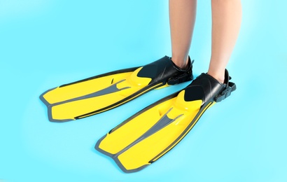 Photo of Woman in swimming flippers on color background, closeup