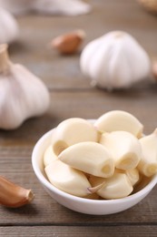 Aromatic garlic cloves and bulbs on wooden table, closeup. Space for text