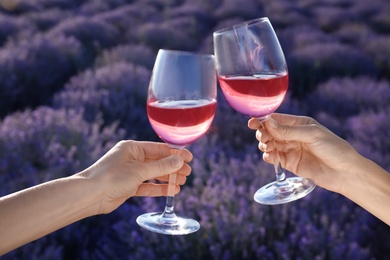 People with glasses of wine in lavender field